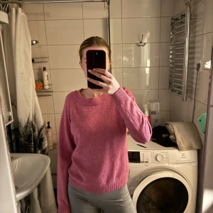Rosa stickad tröja - Mysig rosa stickad tröja med rund halsringning och ribbade muddar vid ärmslut och nederkant. Perfekt för lager-på-lager och enkel att matcha med jeans eller kjol.