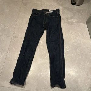 Mörkblå jeansbyxor Tiger of Sweden - Snygga mörkblå jeansbyxor i klassisk femficksmodell. Byxorna har gylf med dragkedja och knapp, samt kontrastsömmar.  Storleken är 31/34.