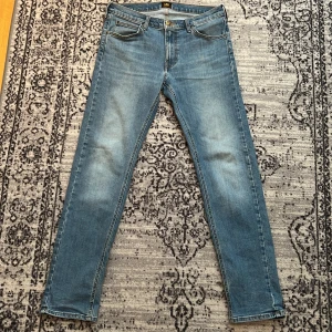 Ljusblå Daren Zip Fly jeans från Lee - Säljer ett par ljusblå Daren Zip Fly jeans från Lee med raka ben och femficksmodell. Jeansen har normal passform. 