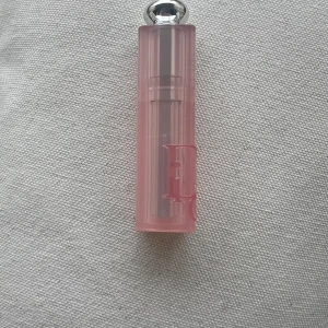 Dior Lip Glow Color Reviver Balm 004 Coral - Dior Lip Glow Color Reviver Balm i nyansen 004 Coral. Läppbalsamet har en mjuk, korallrosa färg och kommer i en lyxig rosa hylsa med silverdetaljer. Perfekt för att ge läpparna en naturlig glans och återfuktning.Kommer utan förpackning, oanvänd och otestad, om du köper fler av dessa läppstift kan jag tänka mig bättre pris. Rensning inför flytt