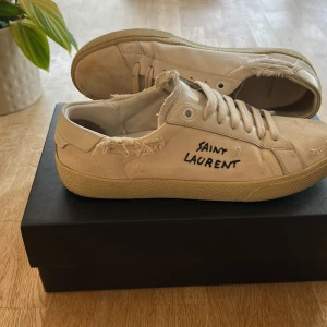 Saint laurent skor - Säljer ett par feta vita saint Laurent skor. De har snygga detaljerade slitningar. Storlek 39 men passar runt 40-40,5. Bra skick.