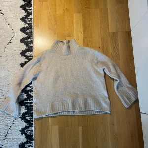 Beige stickad polotröja från H&M - Mysig beige stickad polotröja från H&M. Tröjan har lång ärm, hög polokrage och en avslappnad passform. Storlek S, Loose Fit. 