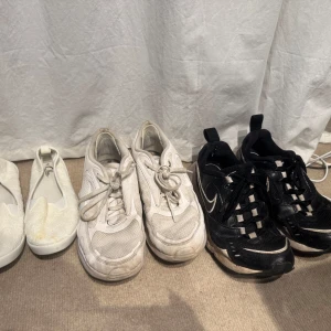 Tre par skor: vita ballerinaskor, vita sneakers och svarta sneakers - Säljer tre par skor: ett par vita ballerinaskor med broderade blommor, ett par vita sneakers med snörning och mesh-detaljer samt ett par svarta Nike sneakers med vita detaljer och snörning. Säljes gärna som paket i befintligt skick! Ballerinaskorna är i strlk 38. Svarta i 39 och de vita något större, runt 40. 🌺 Kika gärna mina andra annonser. Allt måste bort inom 1 månad annars skickas de till välgörenhet🌺