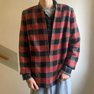 Tunnare rutig jacka - Säljer en snygg overshirt/jacka med rutigt mönster i rött, svart och vitt. Ett plagg i tantformat för den ballare personen. Med axelvaddar för farmödrar som går o stylea för alla!