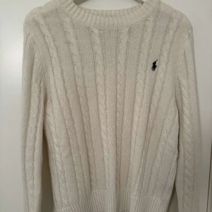 Stickad Polo Ralph Lauren tröja - Säljer en kabelstickad tröja från Ralph lauren i färgen vit/beige. 