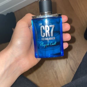 CR7 Play It Cool parfym - Fräsch herrparfym CR7 Play It Cool av Cristiano Ronaldo. Flaskan är blå med silverdetaljer och svart lock. Doften är sportig och energisk, perfekt för dig som gillar en modern och uppfriskande stil.