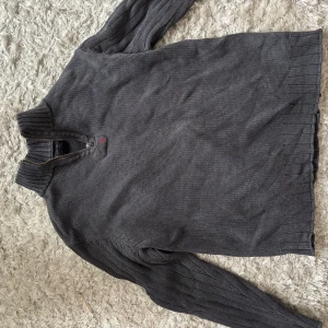 Mörkgrå stickad tröja med half zip - Säljer en mörkgrå stickad tröja med half zip från Ralph Lauren. Köpt på secondhand i Tokyo till min kille men var tyvärr för liten. Står storlek L men passar absolut mer som kanske en S/M. 