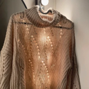 Beige stickad polotröja från ONLY - Säljer en beige stickad polotröja från ONLY med snyggt hålmönster och bred polokrage. Tröjan har lång ärm och är perfekt för lager-på-lager under kyliga dagar. Supermjuk och mysig att bära.