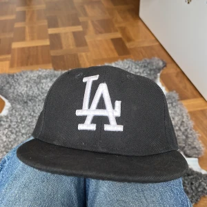 LA fitted cap - Säljer en svart keps med LA-logga i vitt framtill. Inköpt för ca 500 och är i bra skick. Säljer pga ingen använding