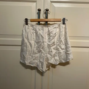 Vita shorts från Lady Avenue - Säljer ett par vita pyjamas silkes shorts från Lady Avenue i storlek XL. De har en lös passform och är tillverkade i ett tunt, mjukt material med resår i midjan. 