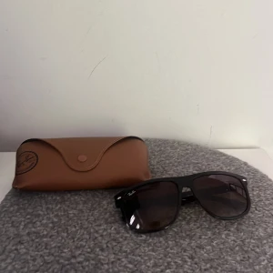 Svarta Ray-Ban boyfriend - Snygga svarta Ray-Ban boyfriend solglasögon pilotform och mörka glas. Kommer med original brunt fodral. Perfekta för att lyfta din stil och skydda ögonen mot solen. Ikonisk logga på skalmen och tidlös design.