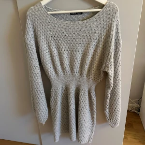 Grå stickad klänning från SHEIN - Supermysig grå stickad klänning från SHEIN i storlek S. Klänningen har lång ärm, markerad midja och ett snyggt hålmönster i hela tyget. Perfekt för lager-på-lager och chill dagar när du vill vara både bekväm och snygg.💞