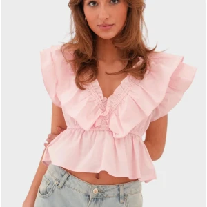 Ljusrosa volangblus med v-ringning - Supersöt ljusrosa blus med volanger med v-ringning. Perfekt att styla med jeans eller kjol för en trendig look. Den är i storlek xxs/xs och helt ny. Den har kvar prislappen. Det är bara att skriva ifall man vill ha fler bilder på den💞 
