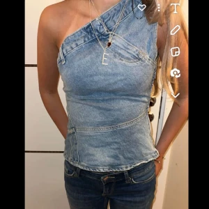 Jeans one shoulder topp - Säljer en snygg asymmetrisk jeans topp som jag köpte här på Plick ( lånad bild). Den är jättefin säljer för att jag inte har fått så mycket användning av den. 