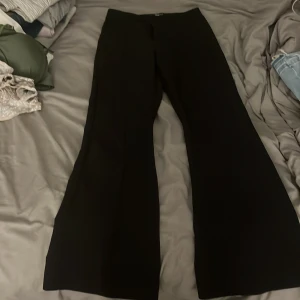 Svarta wide byxor från Gina Tricot XS - Säljer ett par svarta byxor från Gina Tricot i storlek XS. Byxorna har en inte låg men inte hög midja och vida ben för en snygg och trendig siluett. Perfekta att styla med crop top eller oversized hoodie. Materialet känns mjukt och följsamt.