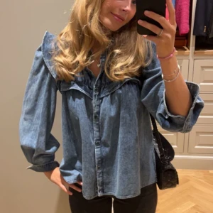Volangblus i denim från Isabel Marant Etoile - Supersnygg blå jeansskjorta med volangdetaljer och rynkad krage från Isabel Marant Etoile. Perfekt att styla med svarta jeans eller kjol för en cool look. I väldigt bra skick, köpt för runt 3500kr. 🤍