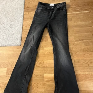 Svarta bootcut jeans från Zara - Snygga svarta bootcut jeans från Zara i storlek 38. Jeansen har klassisk femficksdesign, svarta sömmar och en lätt tvättad look. Modellen har utsvängda ben och normal passform, perfekta till sneakers eller boots.