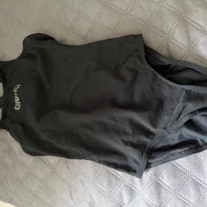 Svart baddräkt från Arena - Säljer en svart, sportig baddräkt från Arena i klassisk modell. Perfekt för simträning eller bad. Tillverkad i 100% polyester för bra hållbarhet och passform. Enkel design med Arena-logga framtill. Helt ny alltså aldrig använd.