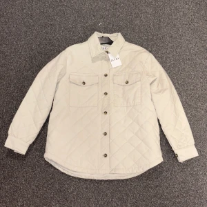 Vit overshirt från Stay, beige - overshirt/jacka i beige från Stay, två bröstfickor med knappar och hel knappslå framtill. Aldrig använd!