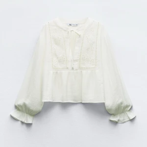 Vit broderad blus från Zara - Superfin vit blus från Zara med broderade detaljer framtill och knyt vid halsen. Vida, långa ärmar med resår och volang vid ärmslut. Luftig och lätt i materialet, perfekt för en bohemisk look.