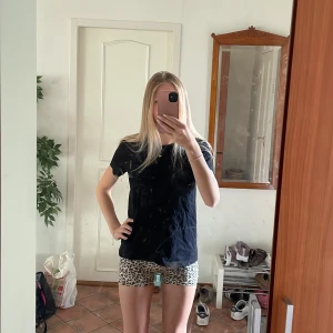 Leopardmönstrade tighta shorts i träningsmaterial - Säljer ett par korta, tighta shorts med leopardmönster i beige och svart. De har en midwaist passform och är gjorda i ett stretchigt syntetmaterial som sitter skönt på kroppen. Perfekta för dig som vill sticka ut med ett djurmönster i sommar. Men kan även användas på gymmet då det är träningsmaterial. Snygg att para ihop med svarta toppar och kan då bli antingen en najs snygg look på gymmet eller till och med en cool outfit på festivaler!