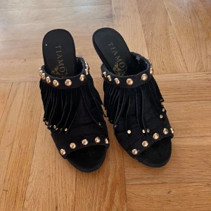 Klackar med fransar - Snygga klackar från TIAMO med fransar och guld knappar!💕jättefina till speciella tillfällen! Tveka inte på att ställa frågor! Dem har lite små defekter på insidan men inget man tänker på🫶pris kan diskuteras!