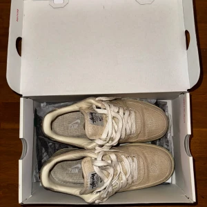Nike Air Force 1 x Stüssy beige - Nike Air Force 1 x Stüssy i beige med canvasöverdel och broderad vit swoosh. Stussy-logga på plösen och häl. Perfekta för dig som gillar streetwear och unika samarbeten. Ovanlig sko, köpta på Stadium Goods i New York och kvitto medföljer. Även original låda och ett par crease protectors vid köp för utropspris. Storlek eu 40.5, us 7.5, uk 6.5. Priset är aningen förhandlingsbart. 