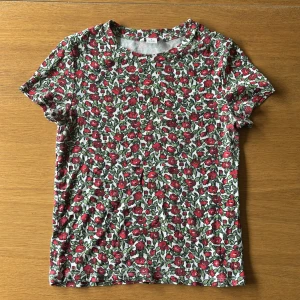 Blommig ribbad topp från Monki - Superfin ribbad topp från Monki med blommigt mönster i rött och grönt på vit botten. Perfekt till jeans eller kjol. ❣️❣️ Strl S!!❣️
