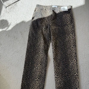 Leopardmönstrade jeans från Supré - Snygga jeans från Supré med leopardmönster i bruna och svarta toner. Modellen är low rise med raka ben och klassisk femficksdesign. 