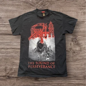 Death The Sound of Perseverance t-shirt - Säljer en svart t-shirt från Ultrakult med Deaths ikoniska logga och 'The Sound of Perseverance'-tryck i rött och vitt fram och bak. Säljer då jag är i behov av pengar.