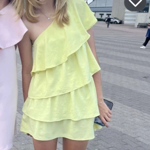 Gul volangklänning med oneshoulder - Säljer min gula volangklänning från Zara! Den är i nyskick med inga defekter. Jag köpte den för 1000kr så säljer för bra pris! 