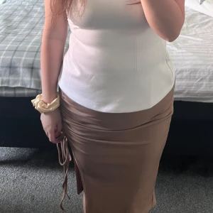 Beige ribbad kjol med snörning - Säljer en beige ribbad kjol med snörning och justerbar slits på sidan. 