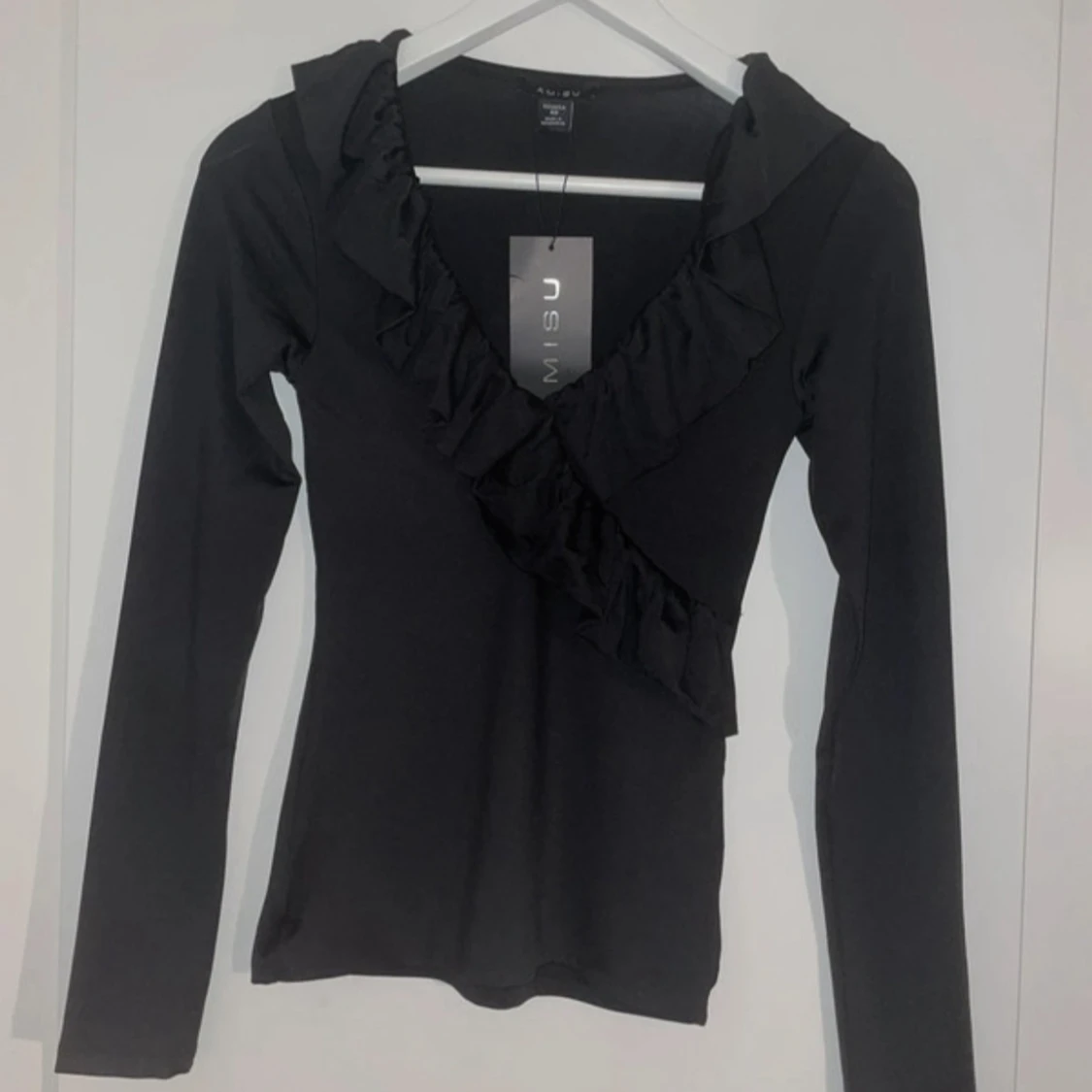 Svart långärmad topp med volang 