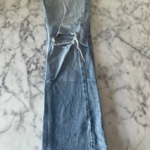 Ljusblå jeans med hål på knät - Säljer ett par ljusblå jeans med ett stort hål på ena knät. Använda ett fåtal gånger. 