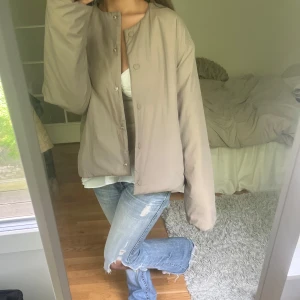 Gullig beige jacka  - Säljer en beige quiltad jacka med rund halsringning och tryckknappar framtill. Jackan har en rak och lite oversized passform, perfekt att slänga på över en t-shirt eller hoodie. Enkel och stilren design som passar till det mesta. Från only 💕💕