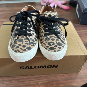 Leopardmönstrade sneakers - Snygga sneakers med leopardmönster och svarta skosnören. Skorna har vit platt sula och rund tå, perfekt för dig som vill sticka ut med din stil. Klassisk sneakerdesign med djurmönster som ger en cool touch. Box ingår ej. Endast änvända 1 gång 