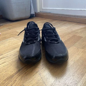 Nya Svarta sneakers från Reebok - Säljer ett par svarta Reebok sneakers med vita detaljer och snörning. Skorna har en sportig design med mesh-ovandel och rund tå. Perfekta för träning eller vardagsstil. 