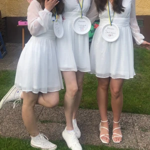 Vit omlottklänning med lång ärm - Superfin vit klänning med knytning i ryggen som passar perfekt till student, examen, konfirmation eller liknande. Endast använd en gång. Jag är till vänster på bilden och är 161 cm för referens🩵 Pris kan diskuteras vid snabb affär