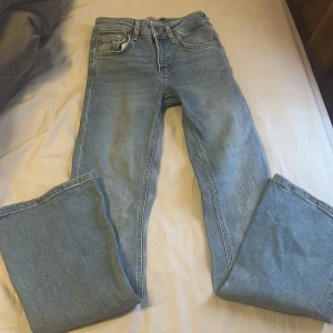 Ljusblå jeansbyxor från 157 - Ljusblå jeansbyxor från 157 med klassisk femficksdesign och låg midja. Modellen är bootcut och har en kortare längd. Perfekta för dig som gillar en tidlös och enkel stil.