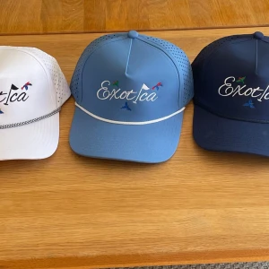 Golfkepsar - Säljer tre kepsar från Exotica i vitt, ljusblått och mörkblått. Kepsarna har broderad logga framtill och små färgglada detaljer. Baksidan är i mesh för extra ventilation och kepsarna har böjd skärm.