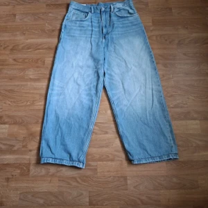 Baggy Loose fit jeans från H&M - Baggy ljusblå jeans från H&M med loose fit och raka ben. Klassisk femficksmodell med gylf och knapp framtill. Perfekta för en avslappnad och trendig look. OBS! JAG HAR SYTT NER BYXORNA TILL 102 CM PÅ LÄNGDEN!