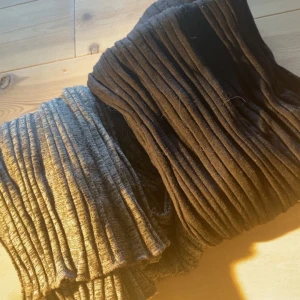 Bootcut byxor från Gina - Byxorna har en tight passform och är tillverkade i ett stretchigt material som sitter snyggt längs benen.  Grå och svarta 