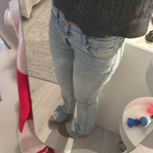 Ljusblå bootcut jeans - Säljer ett par ljusblå jeans med bootcut passform och klassiska fem fickor. Jeansen har normal passning och dragkedja framtill. 