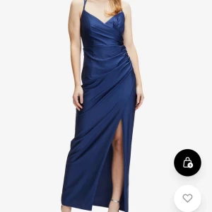 Marinblå långklänning med slits från Suddenly Princess - Snygg marinblå balklänning från Suddenly Princess med smala axelband som korsas i ryggen. Klänningen har v-ringning, draperad midja och en hög slits framtill. Perfekt för bal eller andra tillfällen! Storlek 36, endast testad, lappen kvar.