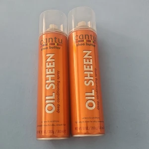Cantu Shea Butter Oil Sheen Spray - Två stora flaskor Cantu Shea Butter Oil Sheen deep conditioning spray. Sprayen kommer i orange metallflaska med svart text och genomskinligt plastlock. Perfekt för att ge glans och mjukhet till håret.