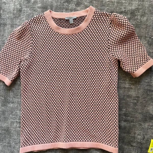 Rosa och svart mönstrad tröja - Säljer en söt tröja i lite tjockare t-shirt material. Snygg till gråa jeans!! Coolt mönster och från cos!!