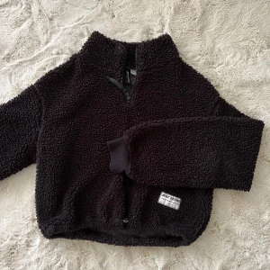 Svart teddytröja från H&M - Mysig svart teddytröja med halv dragkedja framtill och hög krage. 