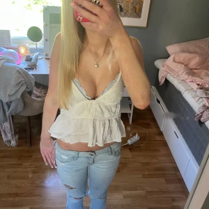 Vit volangig linnetopp - Säljer en söt vit linnetopp med volanger och smala axelband. Den är öppen i ryggen tveka inte vid frågor 💕