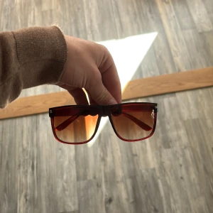 Bruna likande rayban boyfriend - Coola oversized solglasögon med rödtonade bågar och glas. Rektangulär form och markerad ram ger en trendig look. Perfekta för dig som vill sticka ut med accessoarer i färg. Väldigt lika rayban boyfriend