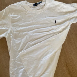 Vit t-shirt från Polo Ralph Lauren - Säljer en Ralph lauren tshirt, använd en gång. Den sitter bra till kroppen. Jag är 175 och den sitter bra, lite för liten. 